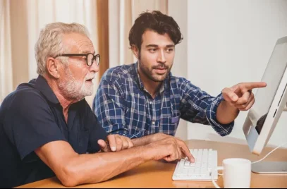 A Wizard pointing at a computer screen beside an older man